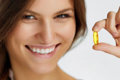 supplement category optimized a smiling woman holding a supplement capsule